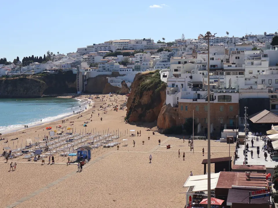 Charming beachfront scene with cascading white-washed buildings and golden sands in Albufeira, Portugal