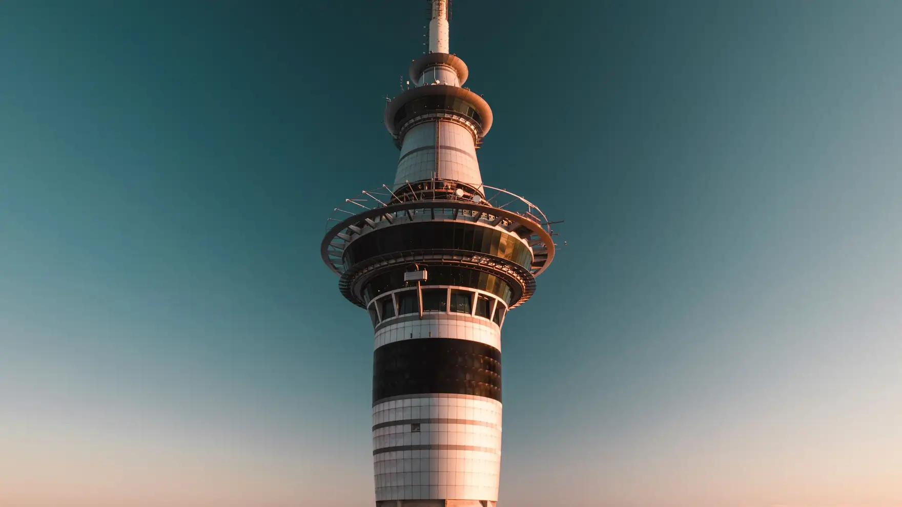 Photograph of the iconic Sky Tower in Auckland, New Zealand against a clear sky at sunset
