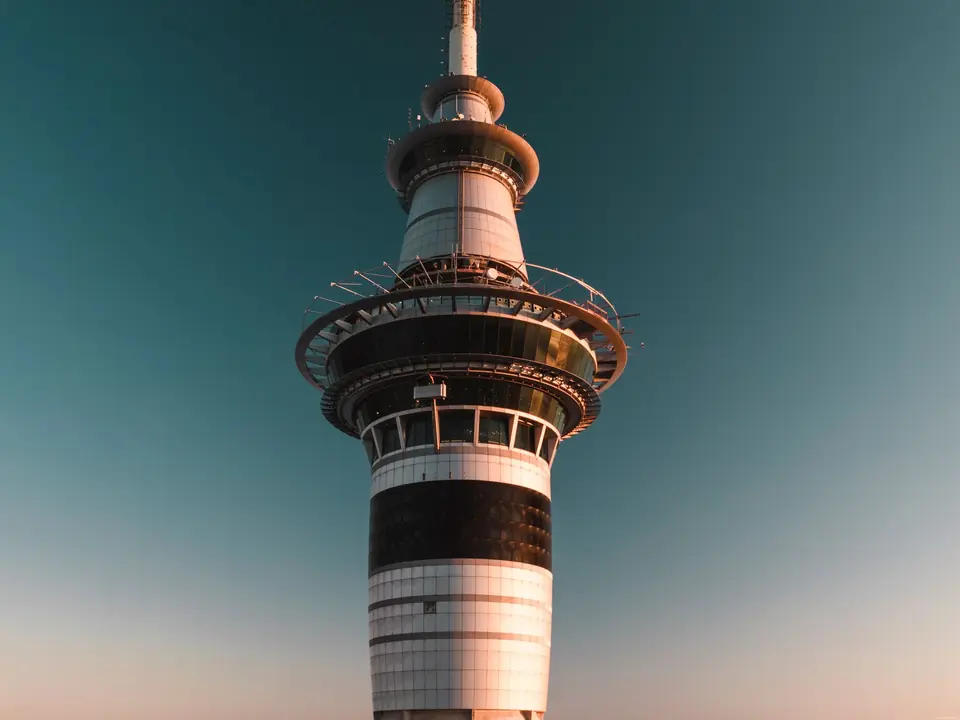 Photograph of the iconic Sky Tower in Auckland, New Zealand against a clear sky at sunset