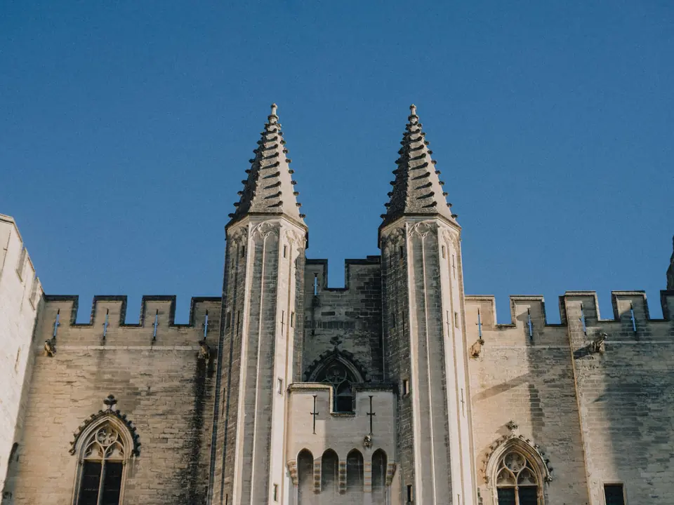 Majestic view of the Papal Palace towers under a clear blue sky in Avignon, France