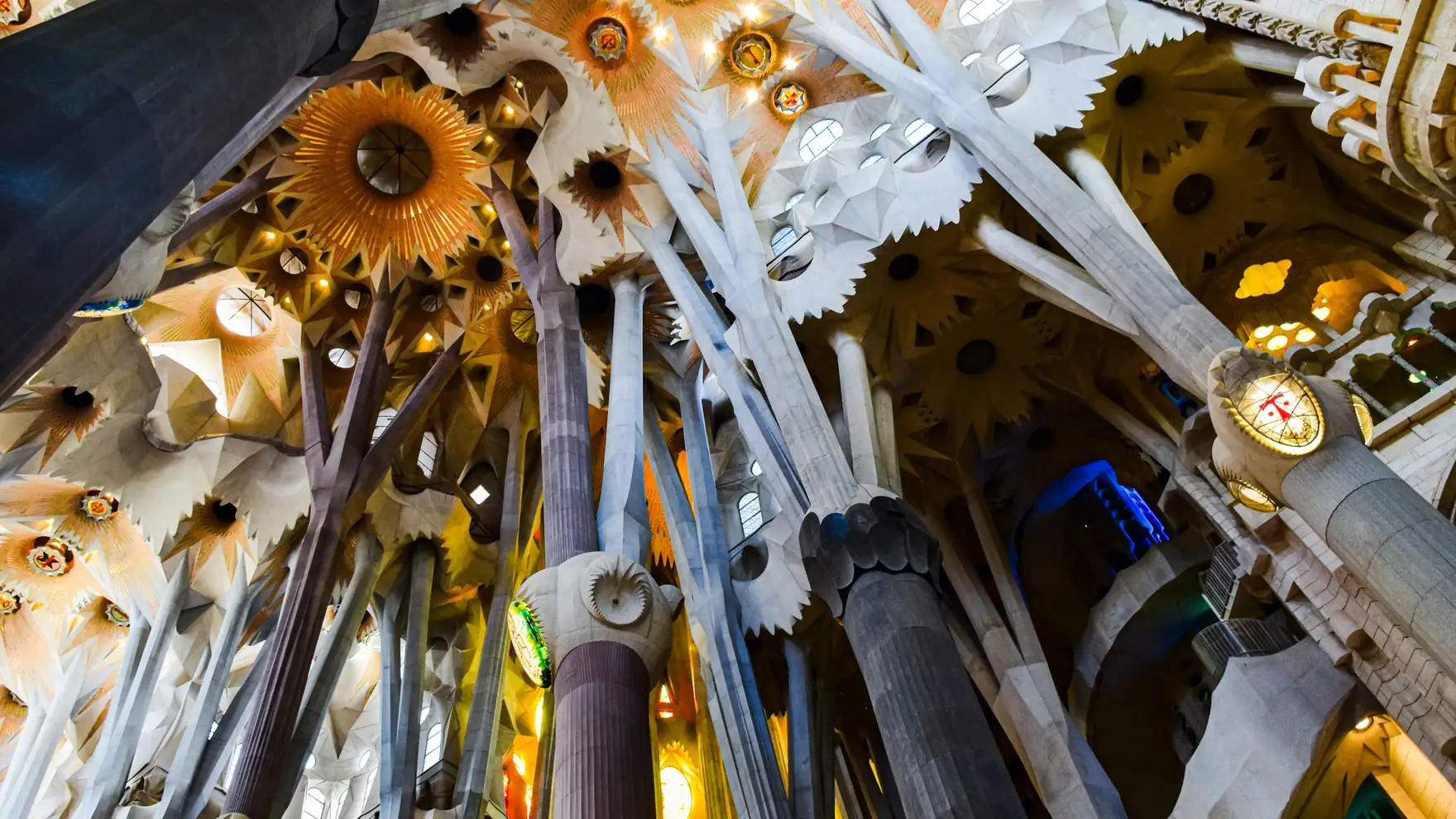 Intricate ceiling and columns of the Sagrada Familia in Barcelona, showcasing Gothic and Art Nouveau styles