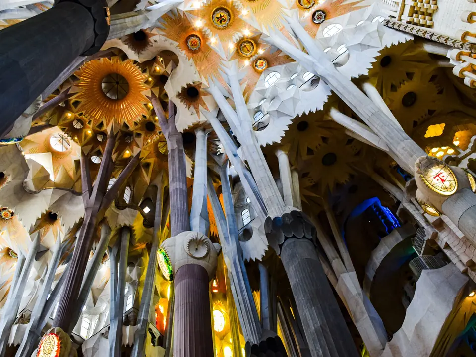 Intricate ceiling and columns of the Sagrada Familia in Barcelona, showcasing Gothic and Art Nouveau styles