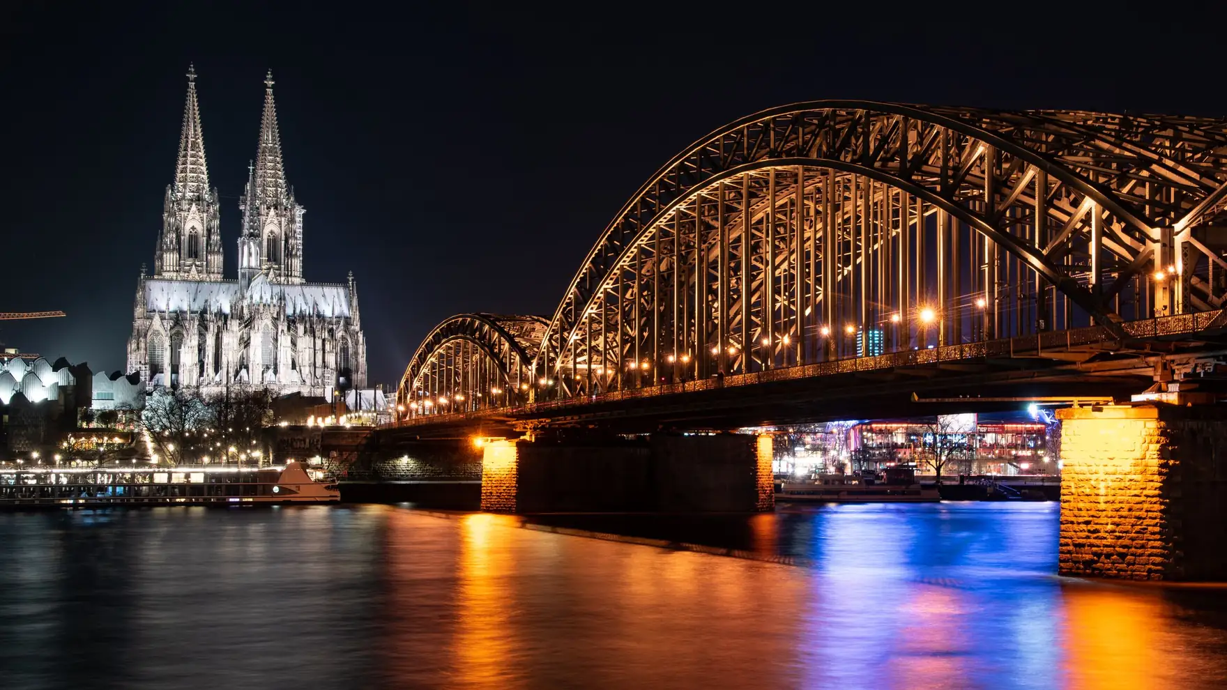 Stunning night view of Cologne Cathedral and Hohenzollern Bridge over the Rhine River in Germany