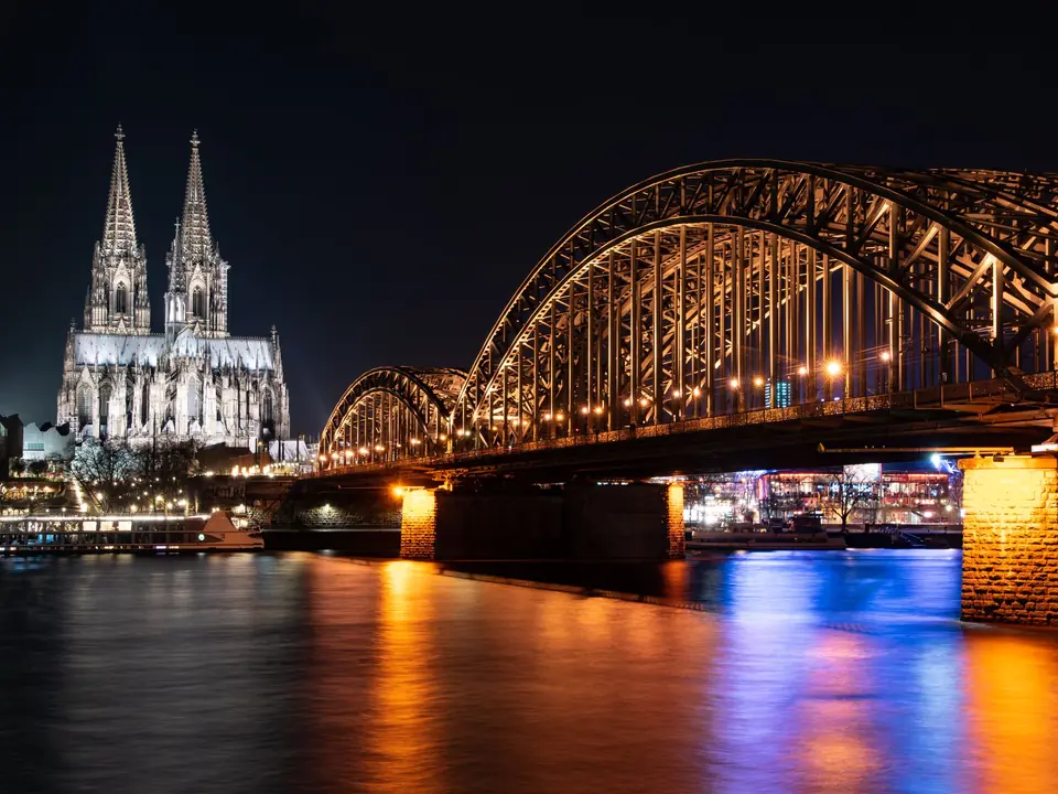 Stunning night view of Cologne Cathedral and Hohenzollern Bridge over the Rhine River in Germany