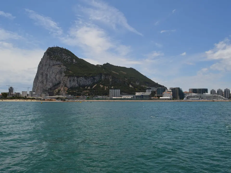 Beautiful view of the Rock of Gibraltar and waterfront buildings under a blue sky