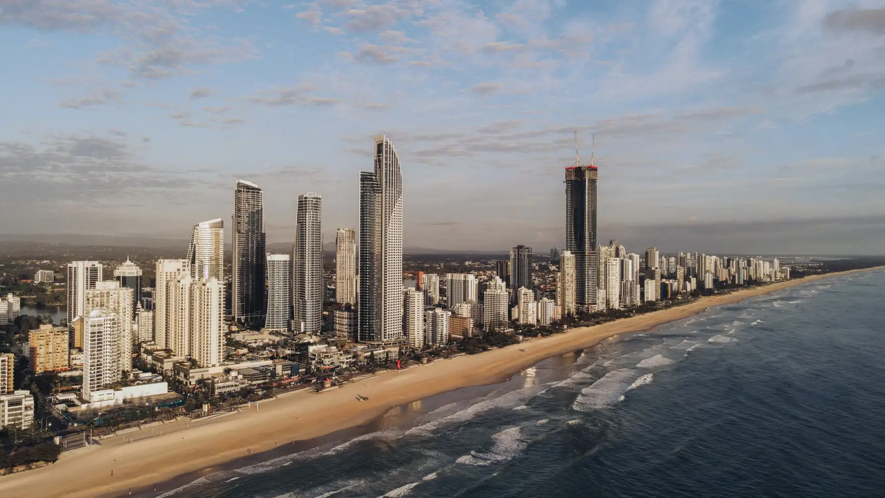 Stunning aerial image of Gold Coast's skyline along the beach at sunrise