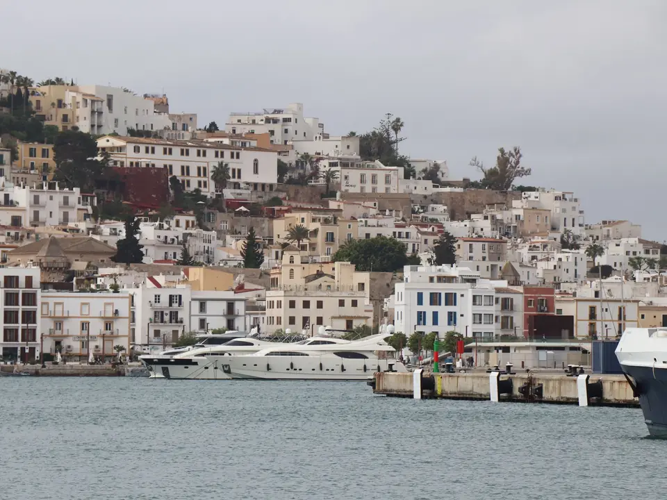Panoramic view of Ibiza's old town architecture and luxury yachts in the marina, Balearic Islands