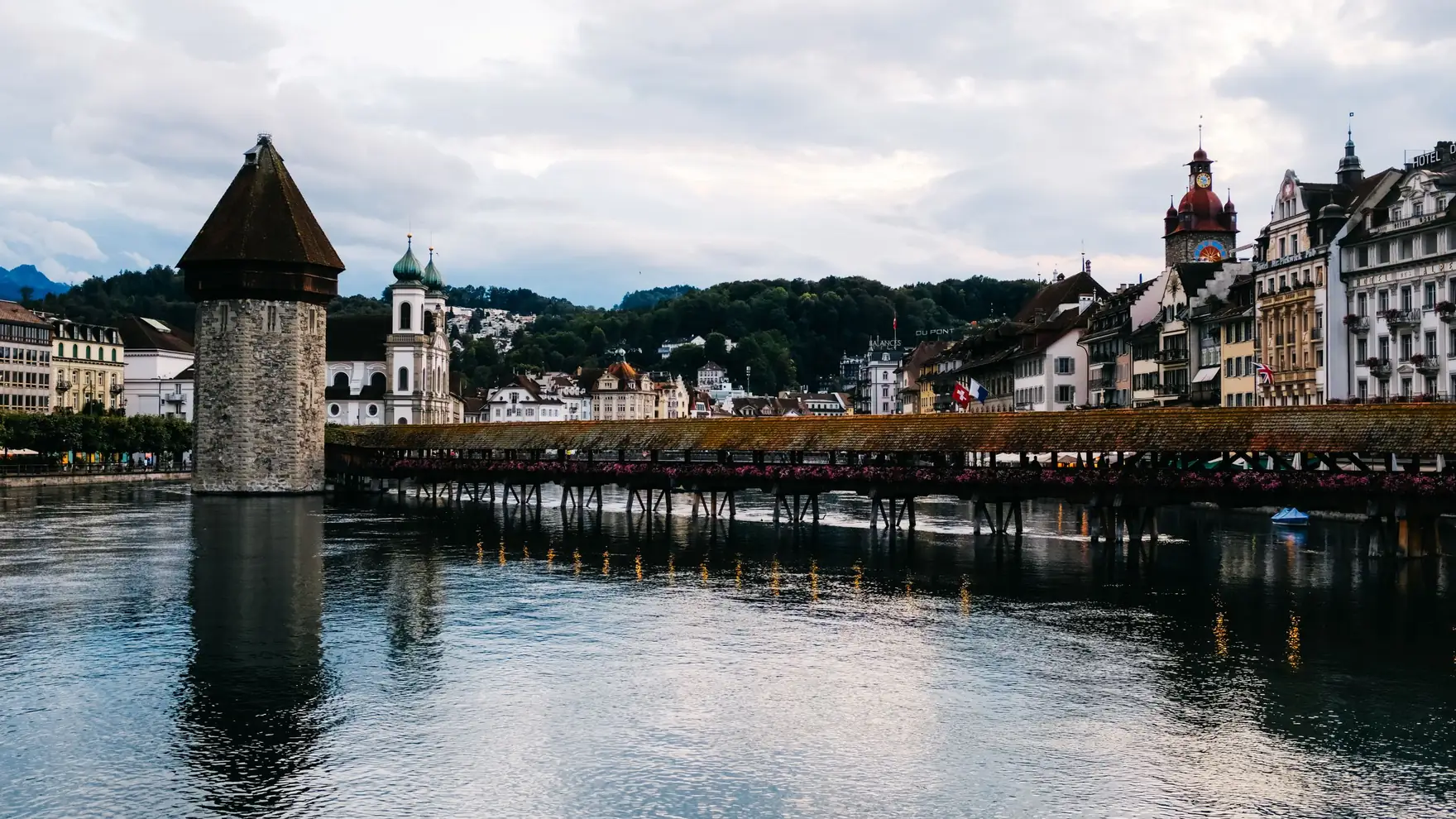 Beautiful view of the Chapel Bridge and Water Tower in Lucerne, reflecting on the Reuss River