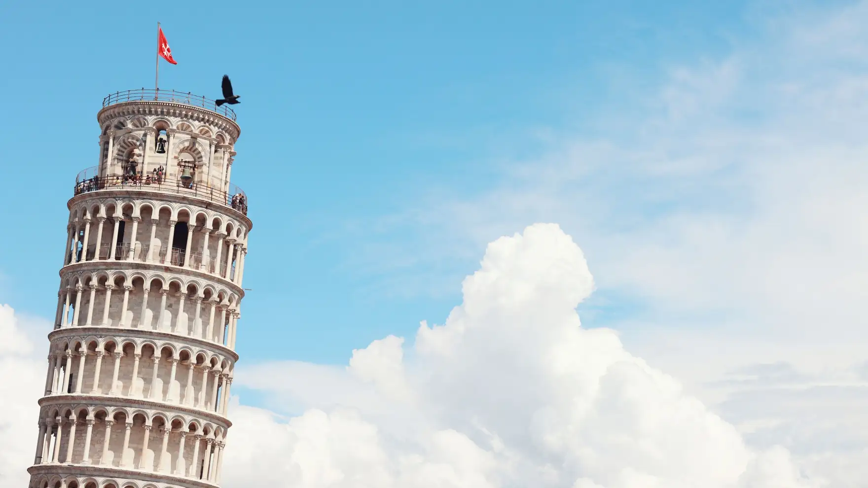 Iconic Leaning Tower of Pisa with clear sky and clouds, a must-see landmark