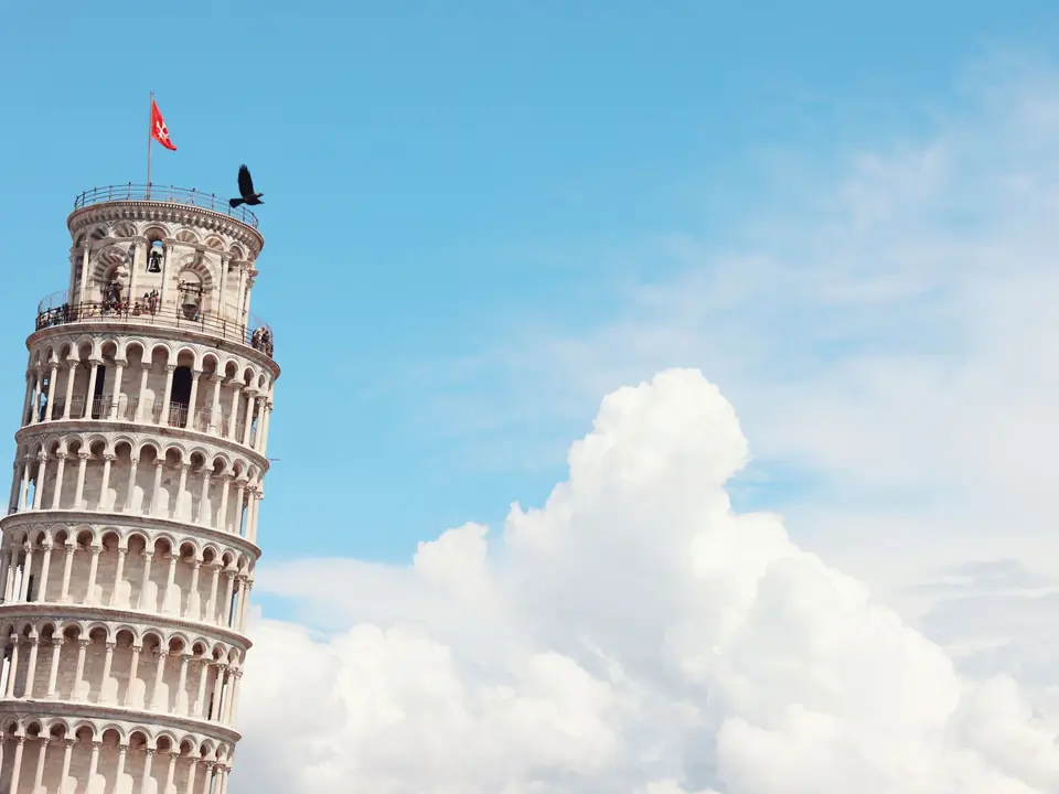 Iconic Leaning Tower of Pisa with clear sky and clouds, a must-see landmark