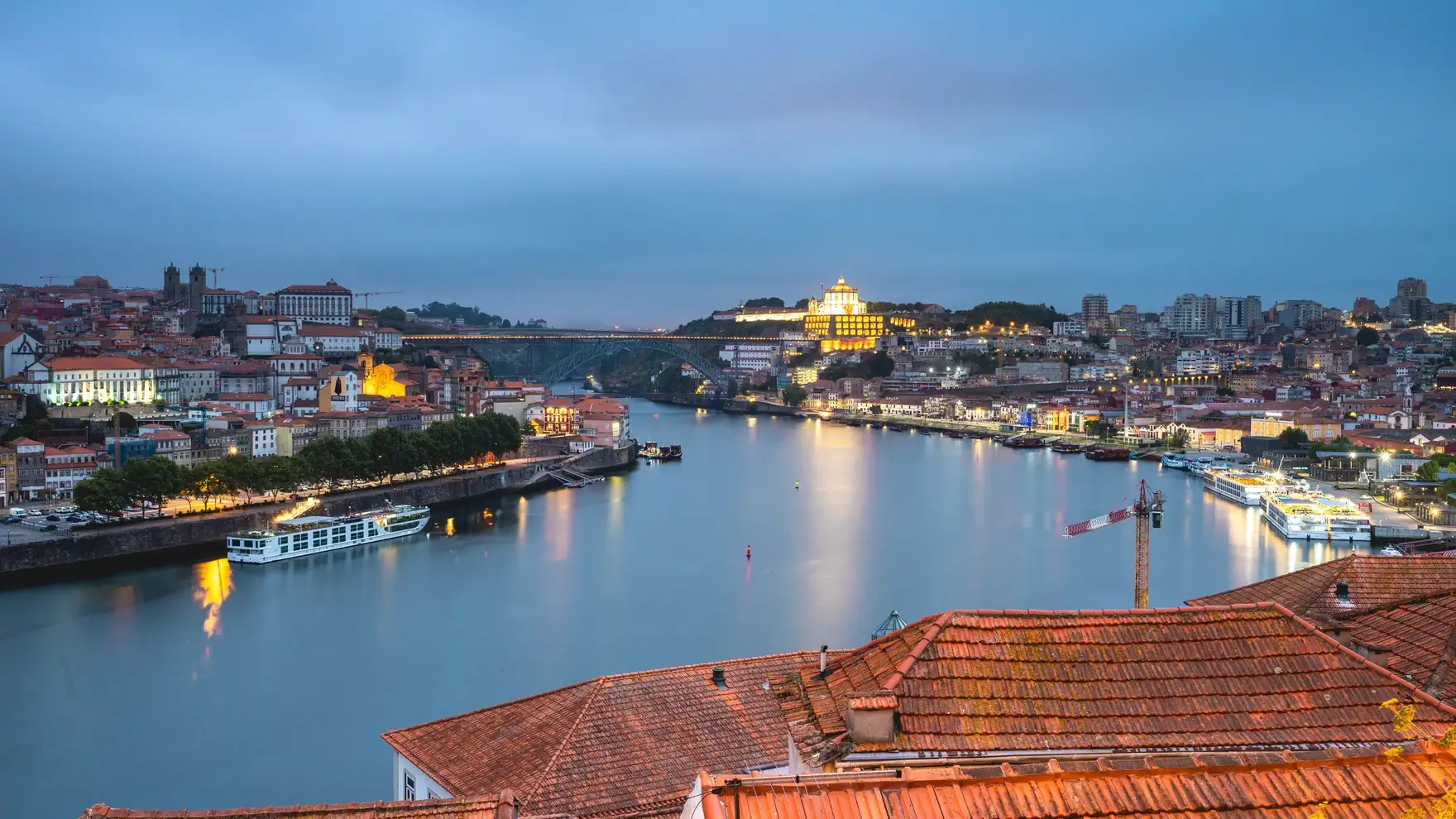 Stunning view of Porto cityscape and Douro River at twilight, highlighting Portugal's architectural beauty