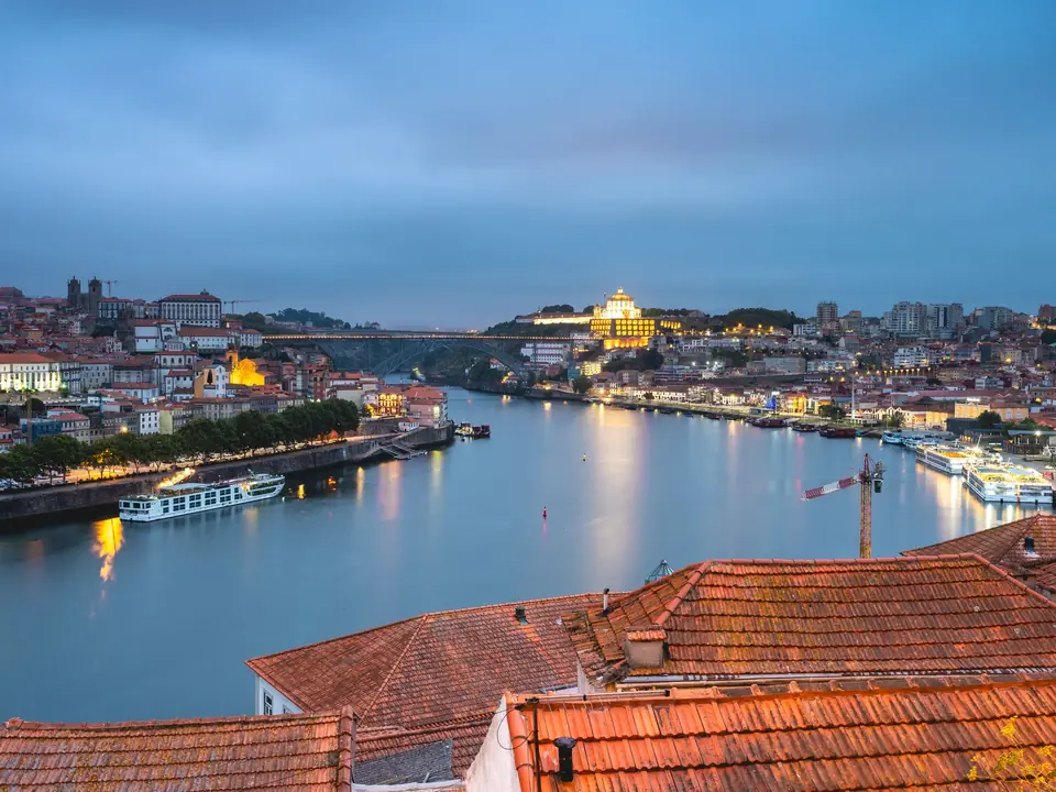 Stunning view of Porto cityscape and Douro River at twilight, highlighting Portugal's architectural beauty