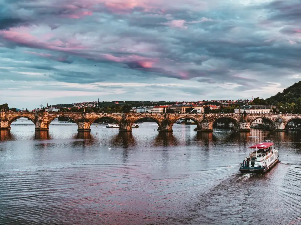 Stunning view of Charles Bridge with vibrant sunset hues over Vltava River in Prague