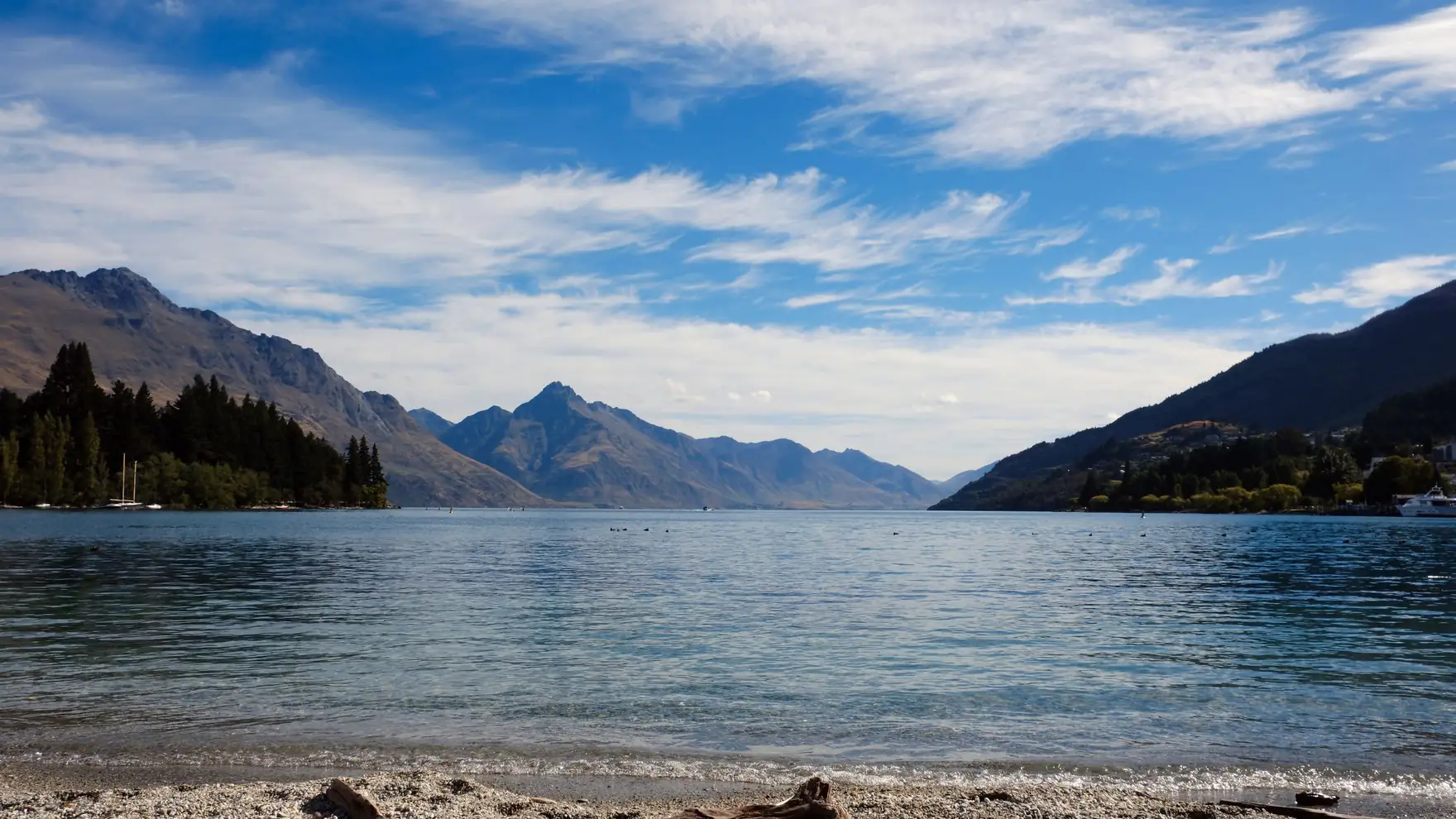 Tranquil views of Lake Wakatipu with surrounding mountains in Queenstown, New Zealand