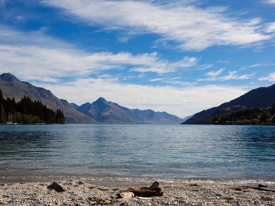 Tranquil views of Lake Wakatipu with surrounding mountains in Queenstown, New Zealand