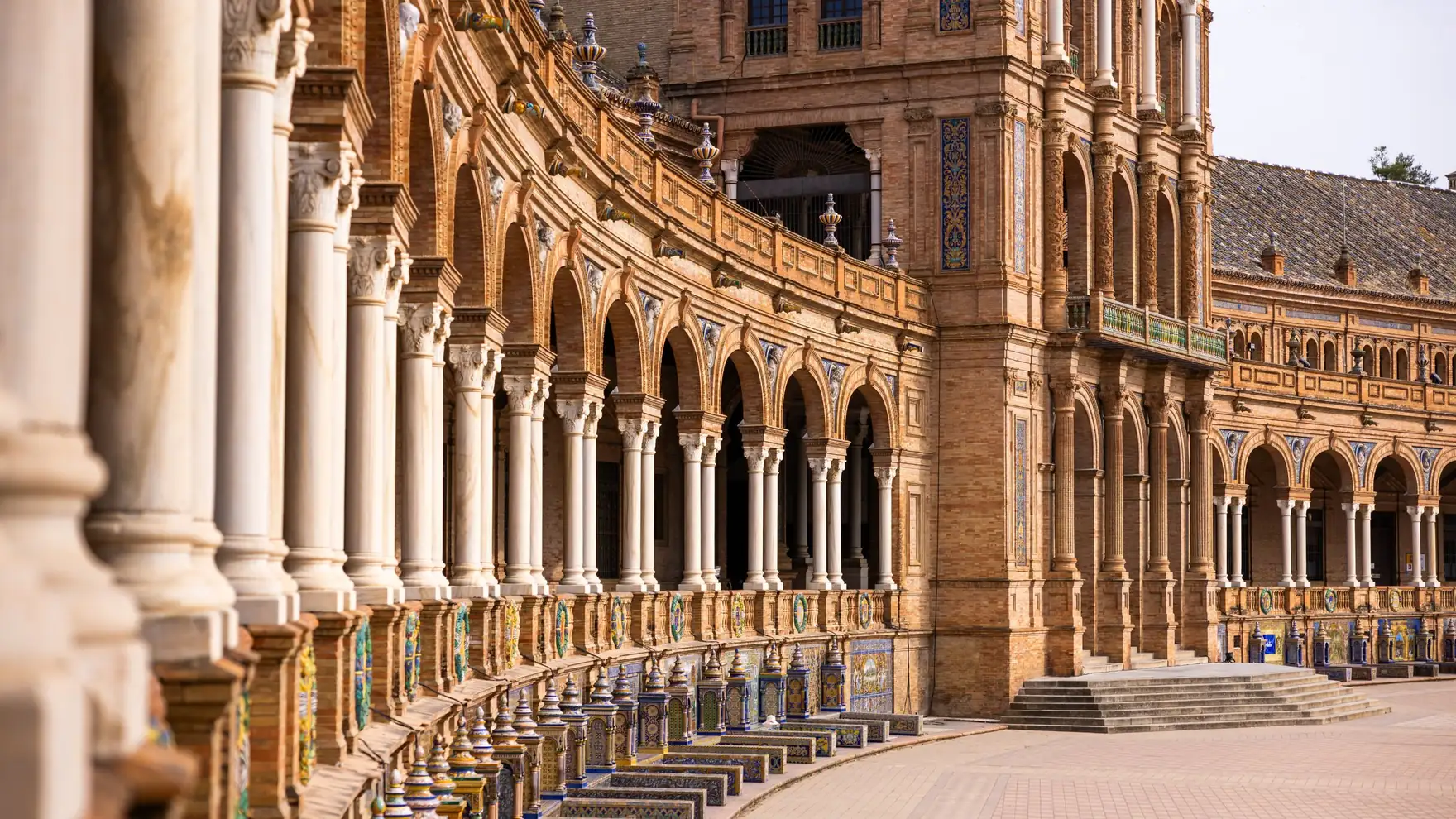 Elegant arches and ornate architecture of Plaza de España in Seville, Spain, showcasing historical grandeur